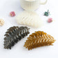 Beau leaf hair clip held in hand displaying size and shape