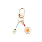 Fried egg keychain held in hand to show size and detail