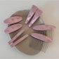 Close-up of pink bow hair clip showing detailed fabric folds