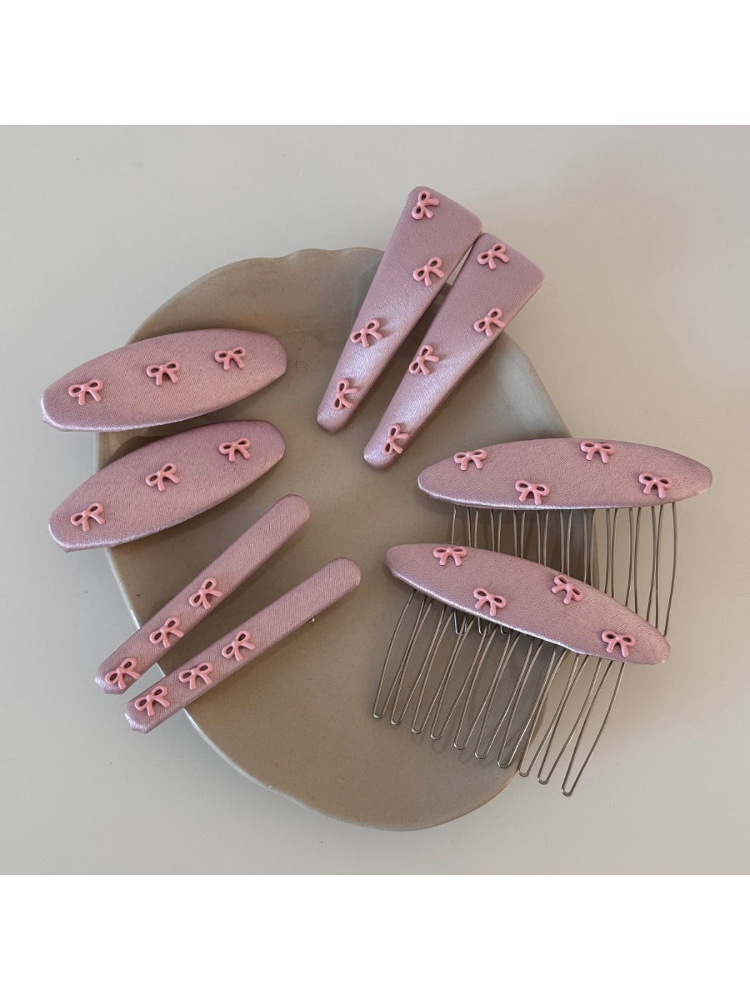 Close-up of pink bow hair clip showing detailed fabric folds
