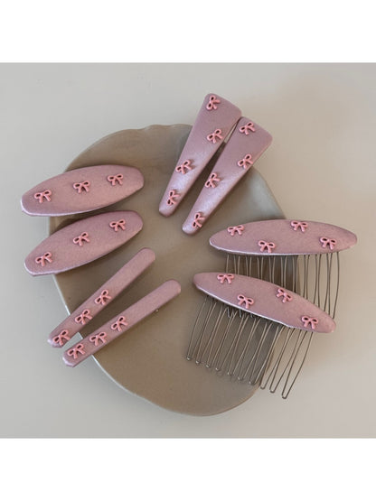Close-up of pink bow hair clip showing detailed fabric folds