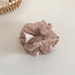 Gifty floral scrunchie paired with matching hair accessories on a wooden surface