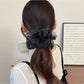 Side view of Gifty minimalist scrunchie highlighting the ruched design and fabric folds