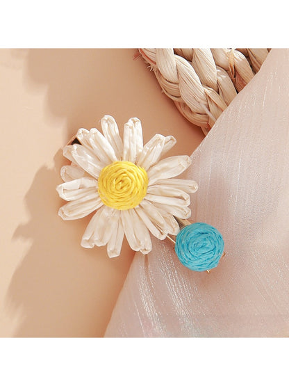 Beau raffia strawberry flower hair clip held in hand displaying size and shape