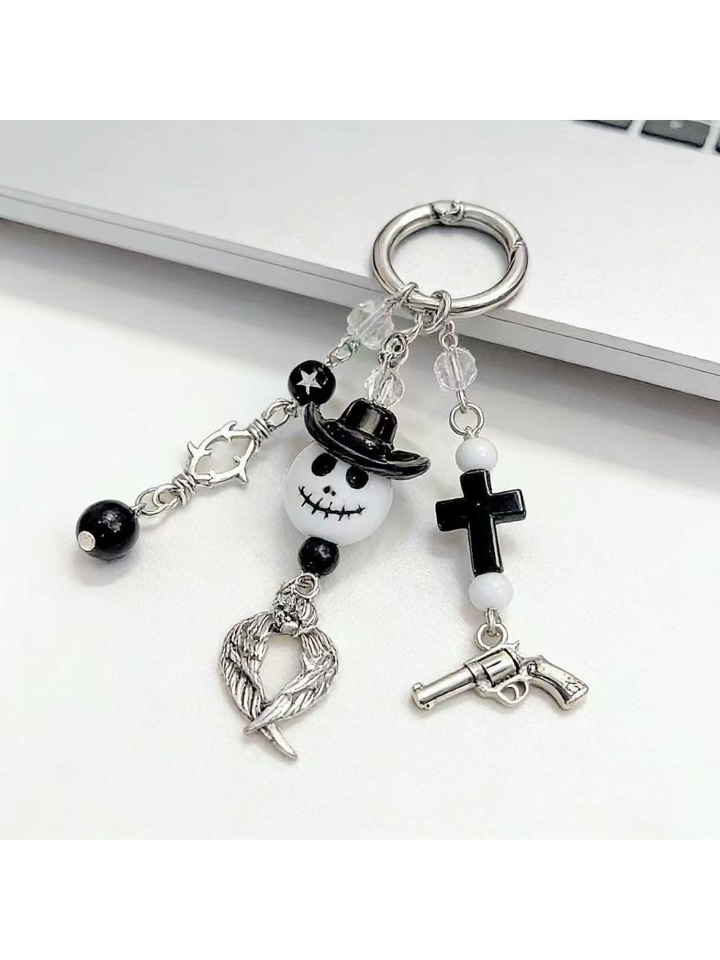Minimalist ghost-shaped pendant keychain in white on a plain background