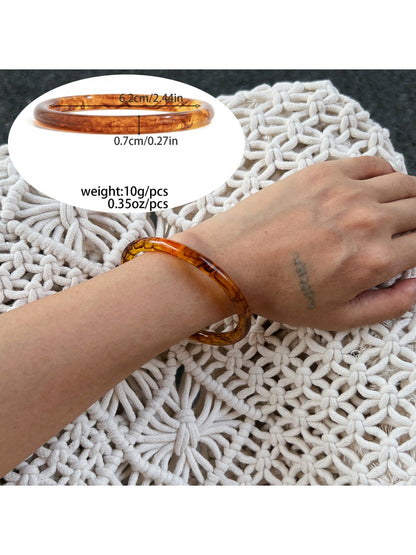 Model adjusting Lovra ombre bangle bracelet on wrist in natural light