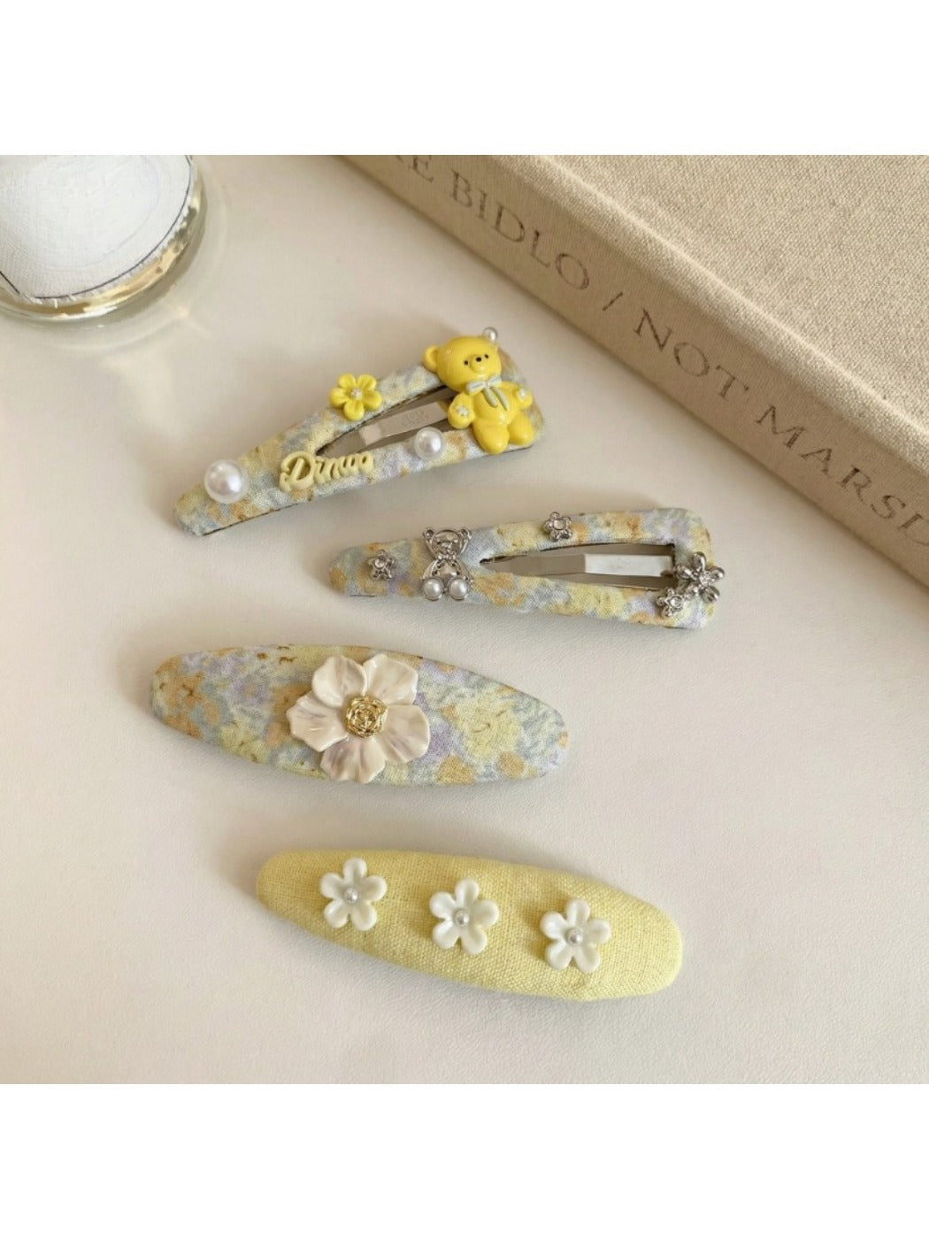 Yellow tiny floral hair clip with small white and orange flowers on a light background