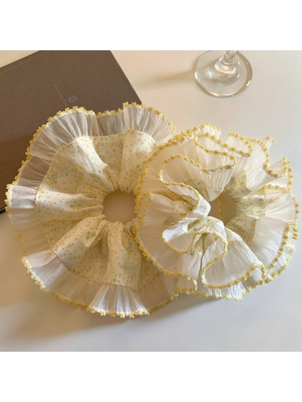 Close-up of yellow pleated fabric and floral pattern on scrunchie