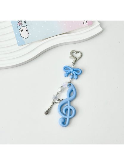 Hand holding the Keypus cute music note keychain against a blurred background