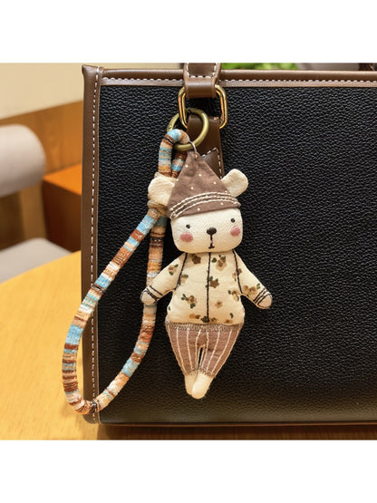 Bear keychain with a trendy hat shown next to keys