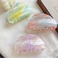 Beau hair claw clip held in hand displaying size and cloud pattern