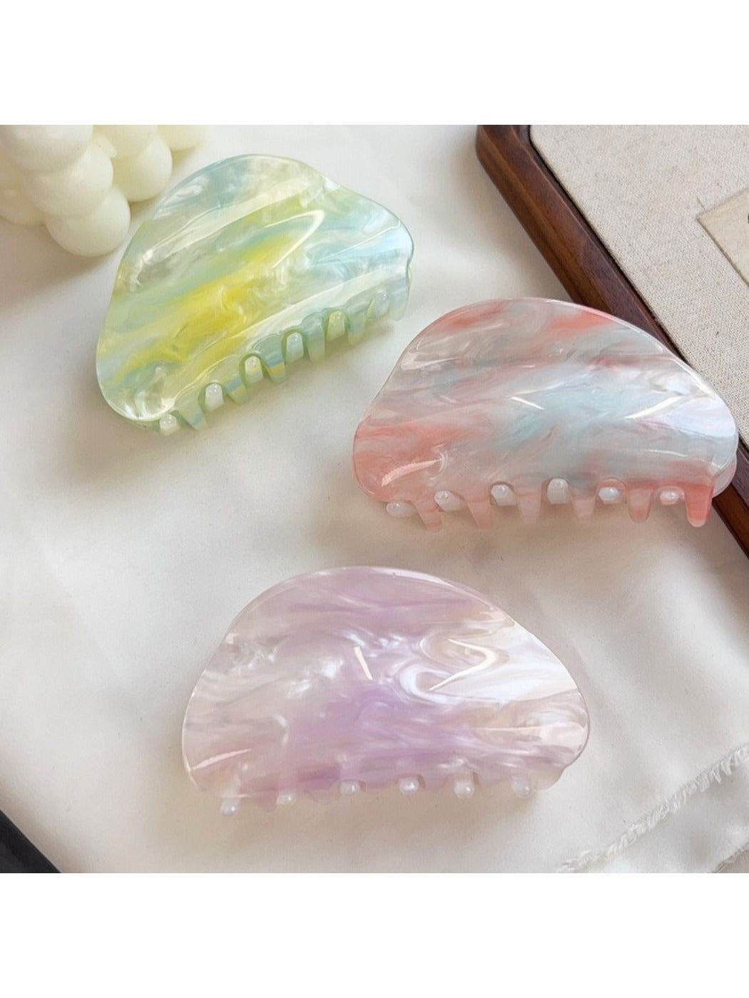 Beau hair claw clip held in hand displaying size and cloud pattern