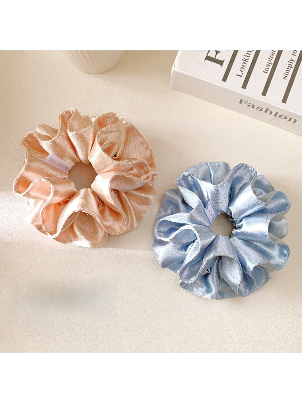 Model wearing Gifty solid satin double layer scrunchie in navy blue holding hair up