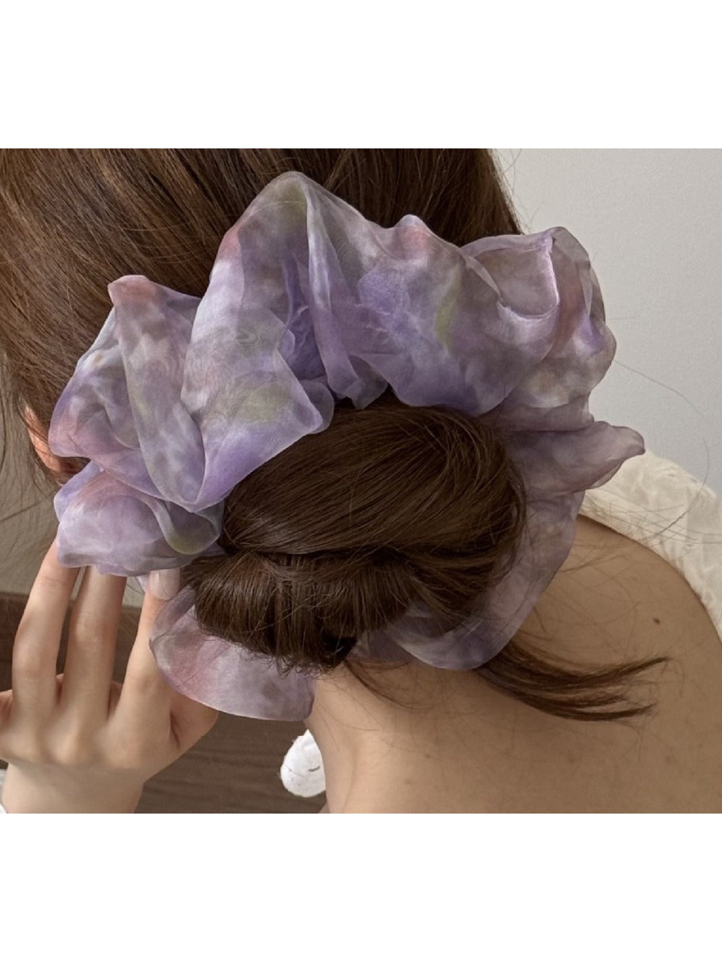 Multi color tulle scrunchie styled on a wrist with soft pastel colors