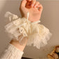 Gifty bow scrunchie styled on a wrist as a fashion accessory