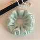 Close-up of green double layered scrunchie showing fabric details