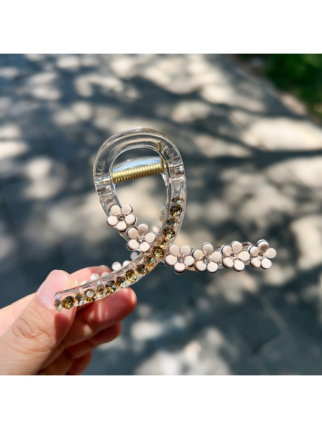Beau floral cross hair claw clip displayed on a wooden surface with natural lighting
