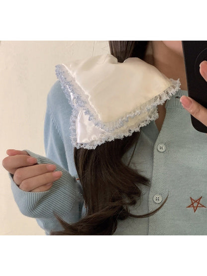Hand holding satin white lace trim scrunchie showing texture and detail