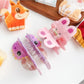 Beau hair claw clip held in hand displaying size and minimalist design
