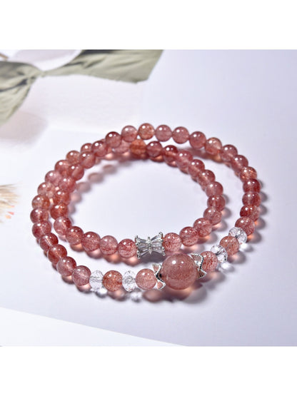 Lovra multi-wrap bracelet displayed coiled with pink strawberry quartz and silver elements