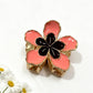 Beau flower hair clip held in hand, showing size and intricate fabric petal details