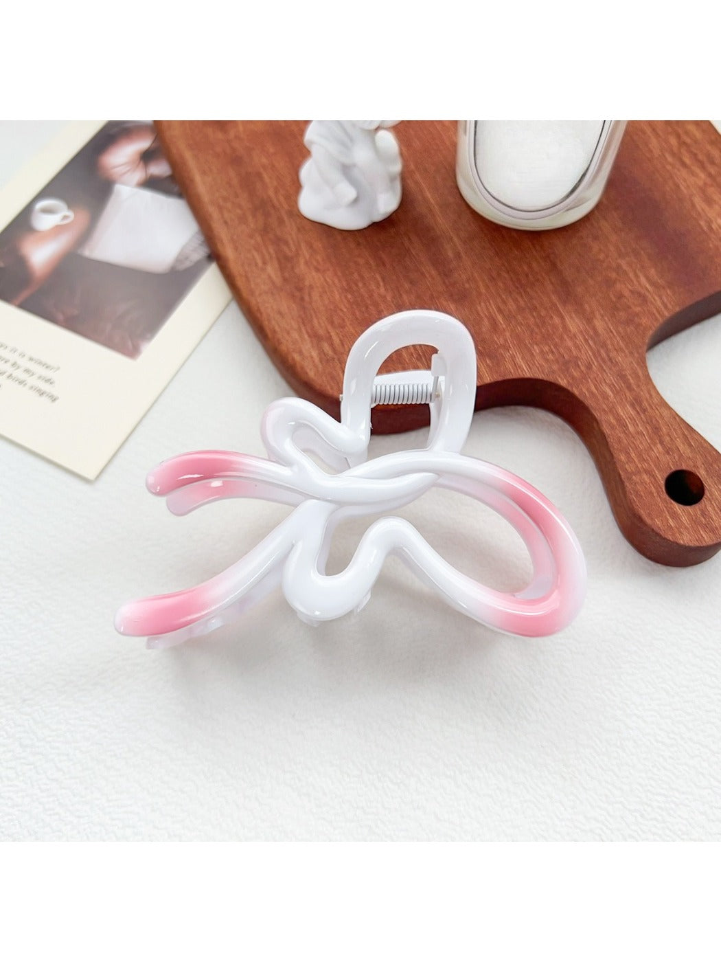 Beau heart shaped bow claw clip in ombre colors next to a ruler for size reference
