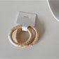 Multiple Gifty satin hair ties stacked showing variety of colors and sheen