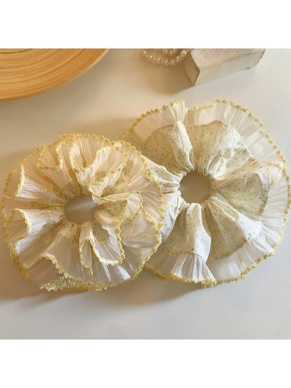Yellow printed scrunchie displayed on a white surface