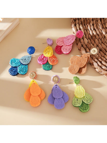 Close-up of Earedge raffia drop earrings showing woven texture and color block design
