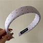 Top view of colorful polka dot headband with twisted knot design