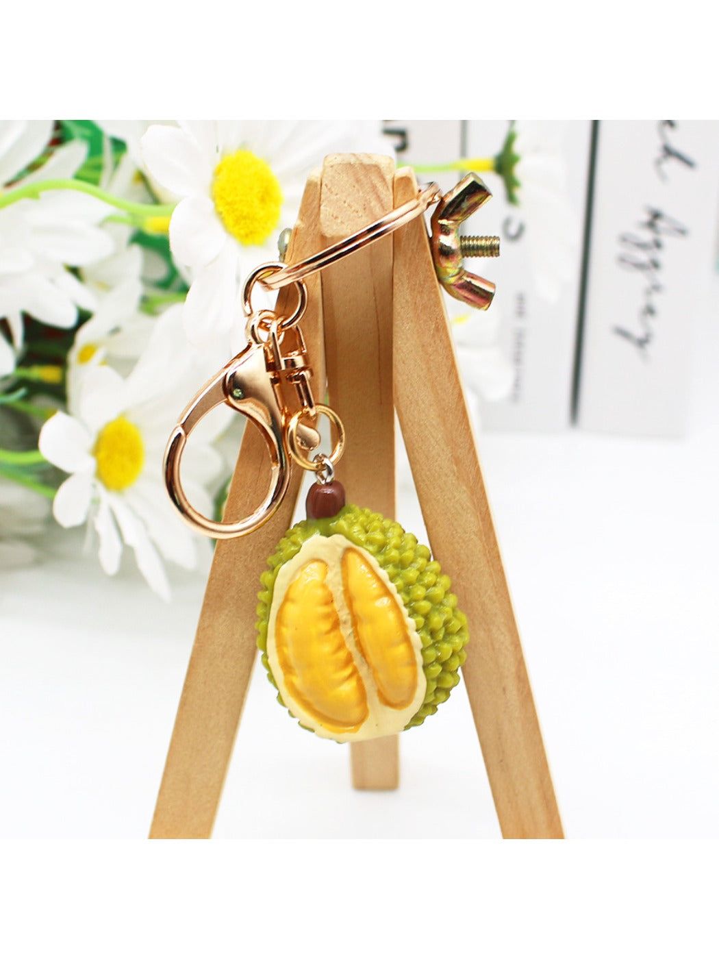Durian shaped keychain displayed next to a real durian fruit for size comparison