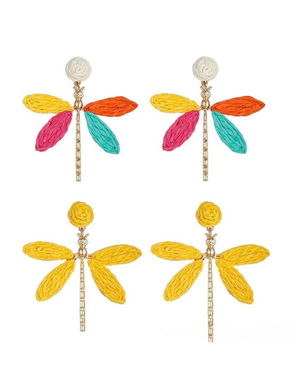 Close-up of raffia dragonfly shaped earring with detailed wings and body