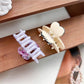 Beau medium heart shaped half circle claw clip held in hand against white background