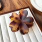 Beau flower shaped claw clip placed on wooden surface