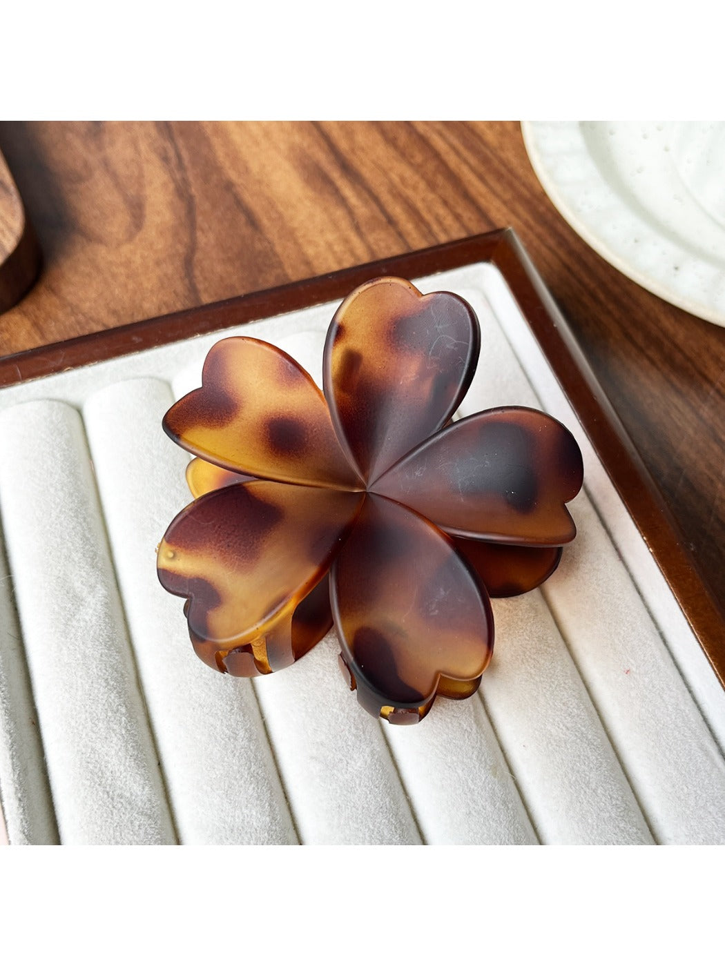 Beau flower shaped claw clip placed on wooden surface