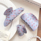 Close-up of blue floral pattern on Beau shark claw clip