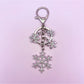 Snowflake pendant keychain resting on a textured fabric surface