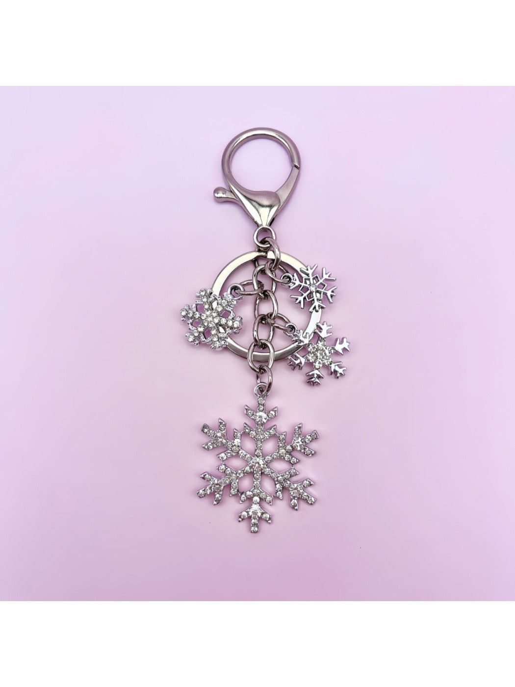 Snowflake pendant keychain resting on a textured fabric surface