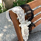 Top view of delicate lace headband with sheer tulle bow detail