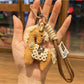 Fabric pony bag charm attached to a set of keys on a white background
