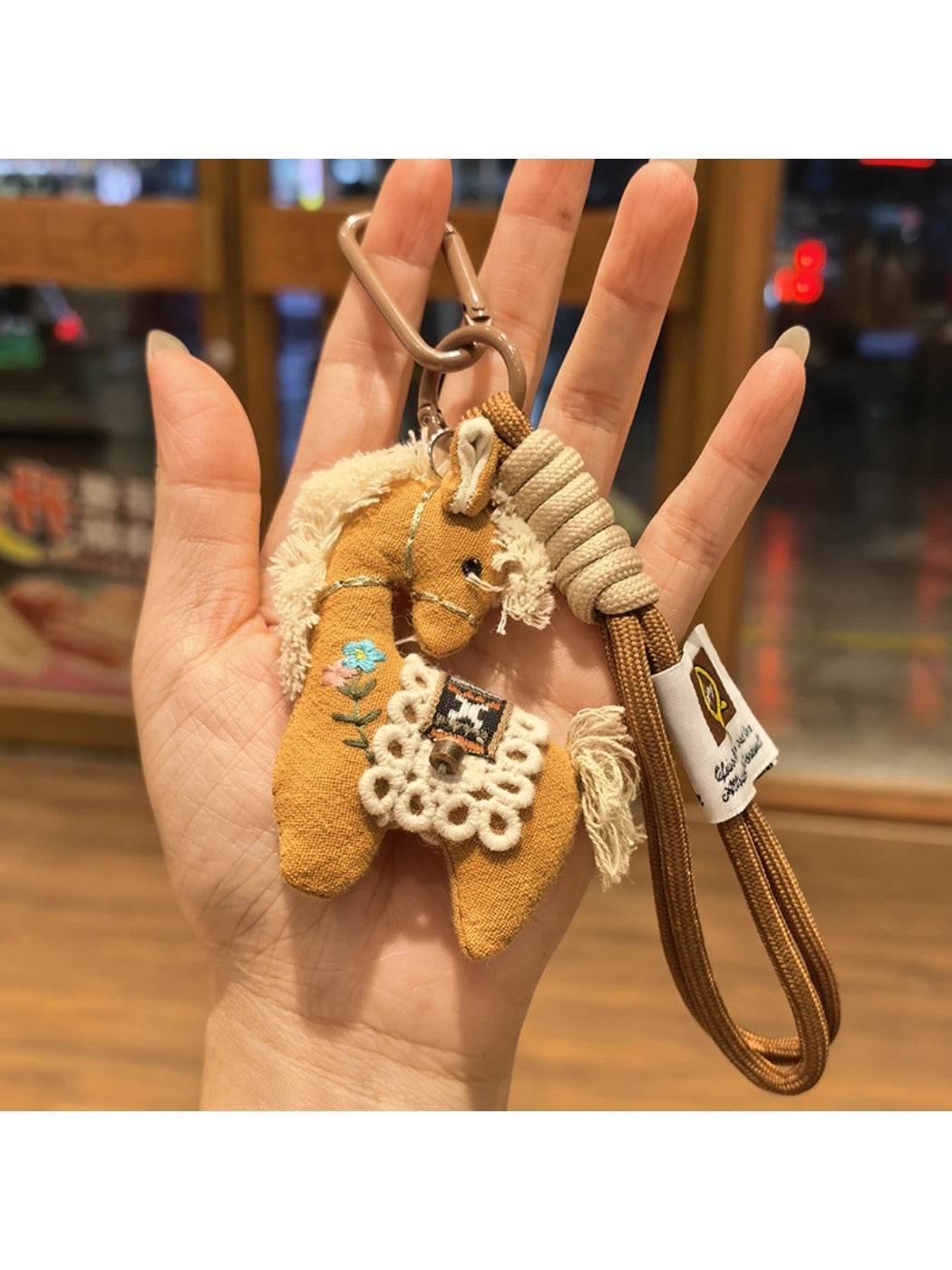 Fabric pony bag charm attached to a set of keys on a white background
