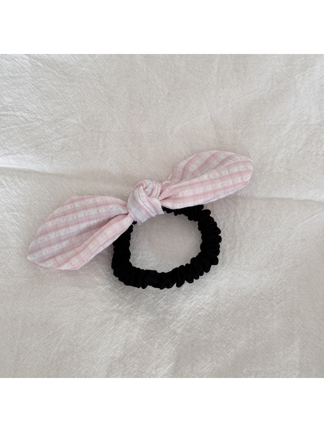 Gifty plaid hair tie with red bow wrapped around a ponytail on a model