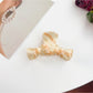 Beau bow shaped claw clip resting on a marble countertop