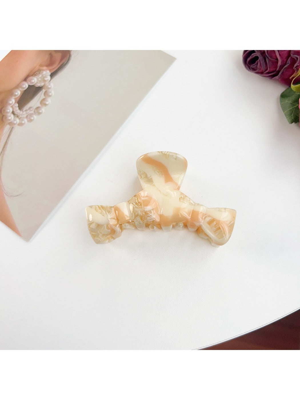 Beau bow shaped claw clip resting on a marble countertop