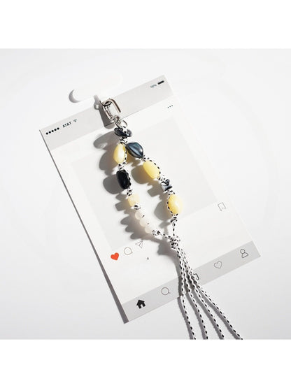 Hand holding a colorful resin bead keychain with a gold ring