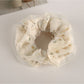 Gifty tulle ruffle scrunchie styled in a ponytail with visible floral accents