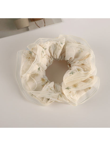 Gifty tulle ruffle scrunchie styled in a ponytail with visible floral accents