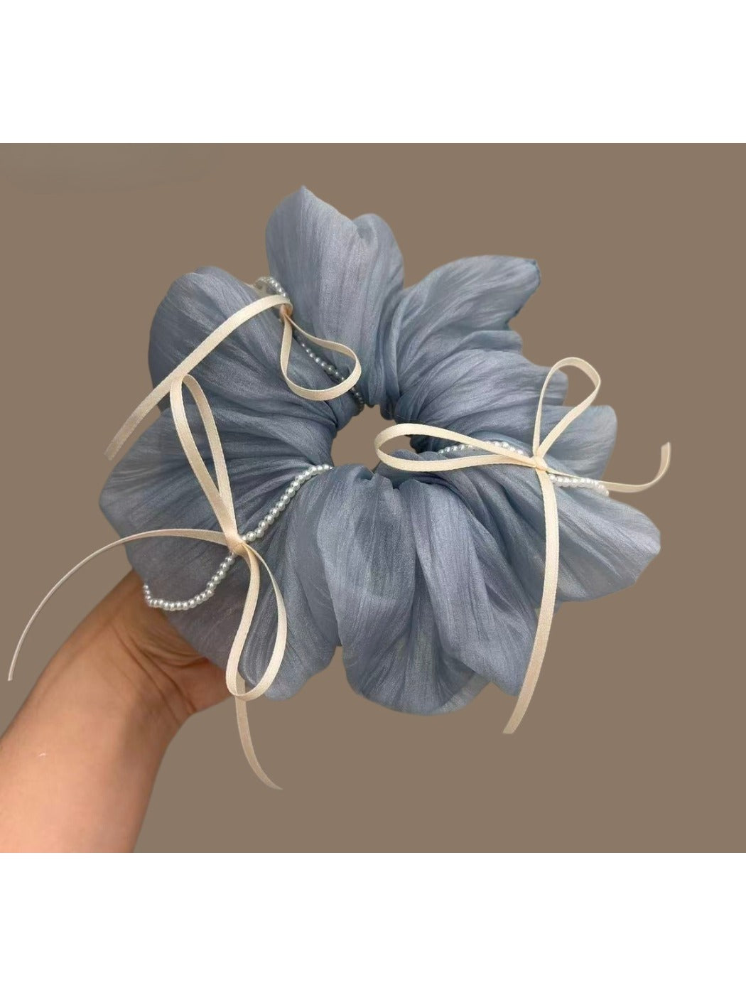 Blue ribbon bow tulle scrunchie worn on a model's wrist