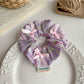 Gifty Ribbon Bow Plaid Scrunchie packaged in a clear plastic bag with branding