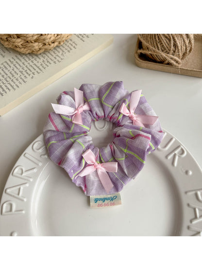 Gifty Ribbon Bow Plaid Scrunchie packaged in a clear plastic bag with branding